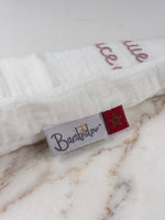 Détail étiquette Bambidou et drapeau marocain sur pochon de naissance en gaze de coton.